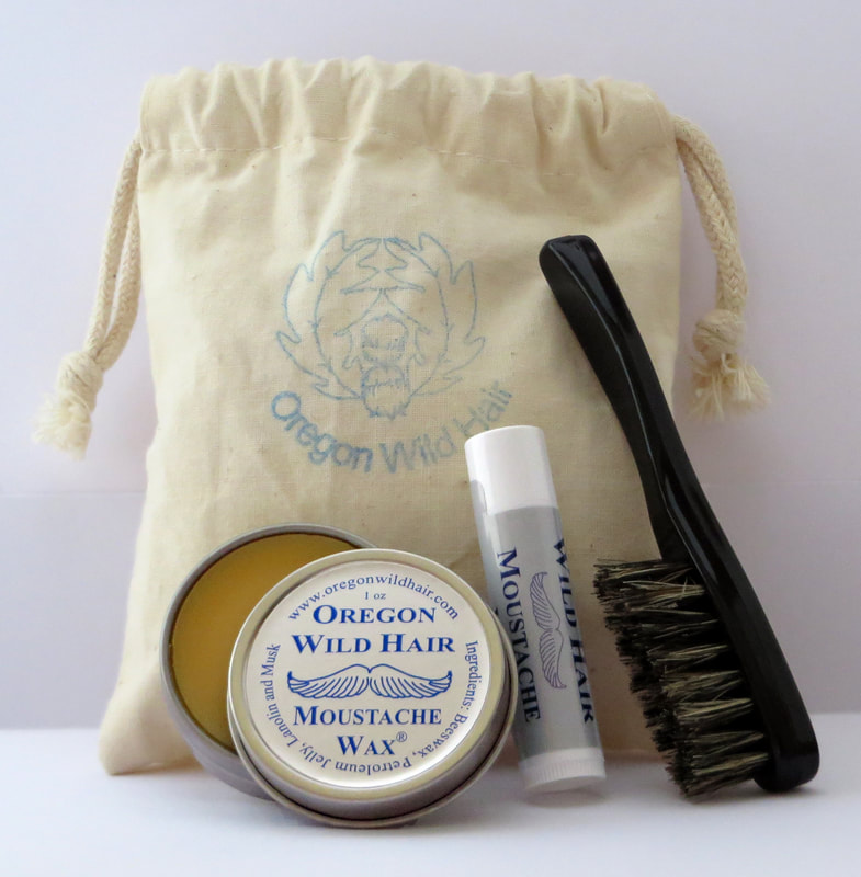 A tin of original formula moustache wax, a tube of wax, and a moustache brush lean against a muslin bag imprinted with a logo.