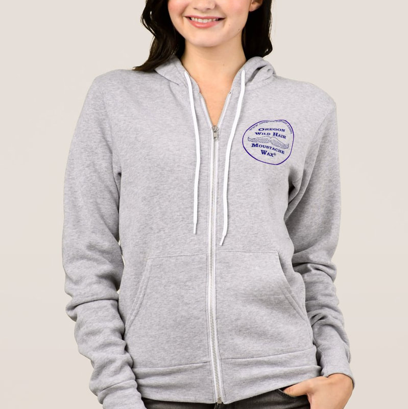 A woman wearing a hooded zip up sweatshirt with a logo on the left side containing the drawing of a moustache and the text Oregon Wild Hair Moustache Wax.